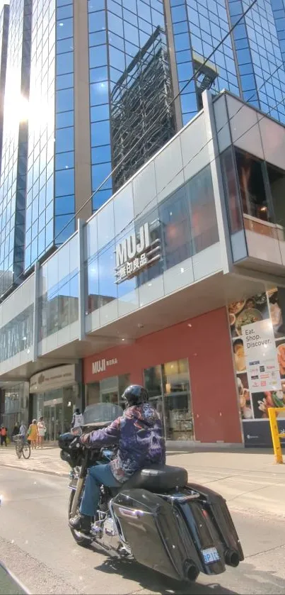 Motorcycle passes a modern glass building in a bustling city scene.