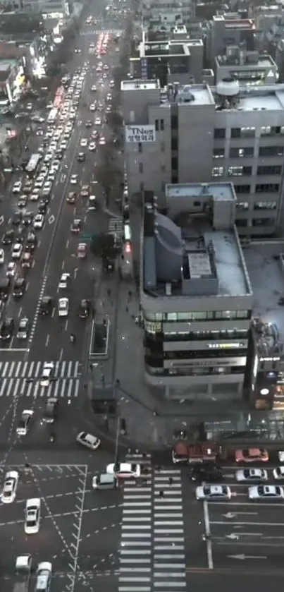 Aerial view of city streets at night with bustling traffic and illuminated buildings.