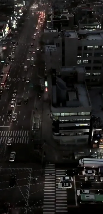 Aerial view of a city street at night with busy traffic and bright lights.