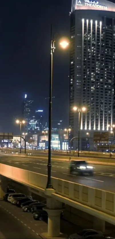 Urban night cityscape with lit skyscrapers and a highway view.