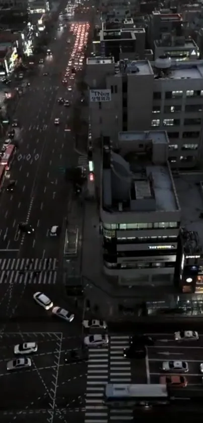 Aerial view of a city street at night with moving traffic and bright lights.