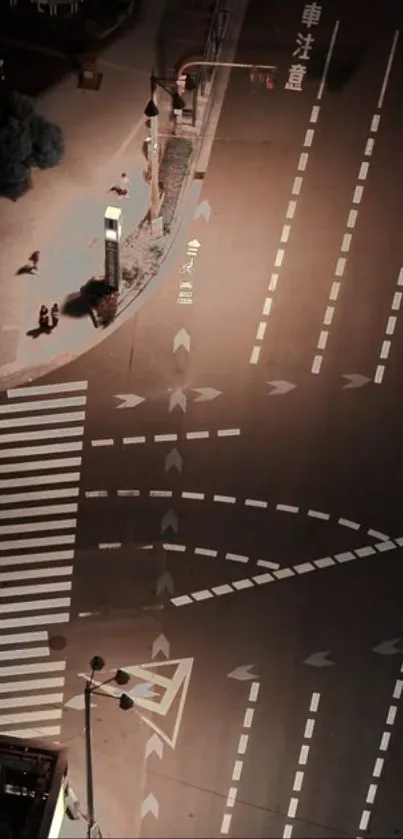 Overhead view of a city intersection at night with illuminated streets.
