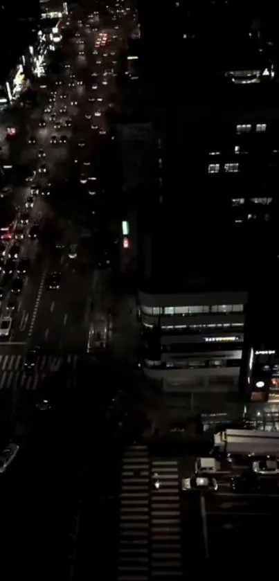 Aerial view of a city street at night with glowing streetlights and traffic.