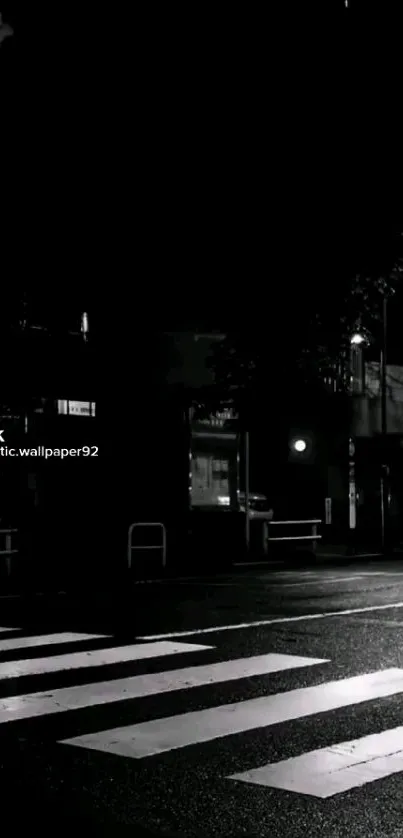 Monochrome city street at night with lights.