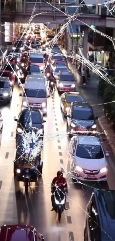 City traffic at night with light reflections and a cracked screen effect.