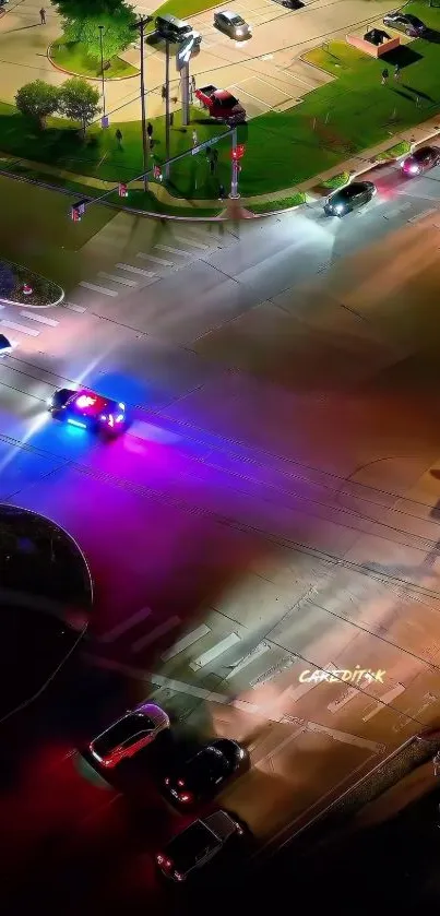 Aerial view of urban intersection with vibrant night lights and moving traffic.