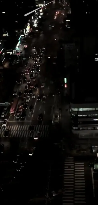 Top view of urban night traffic with city lights and skyscrapers.