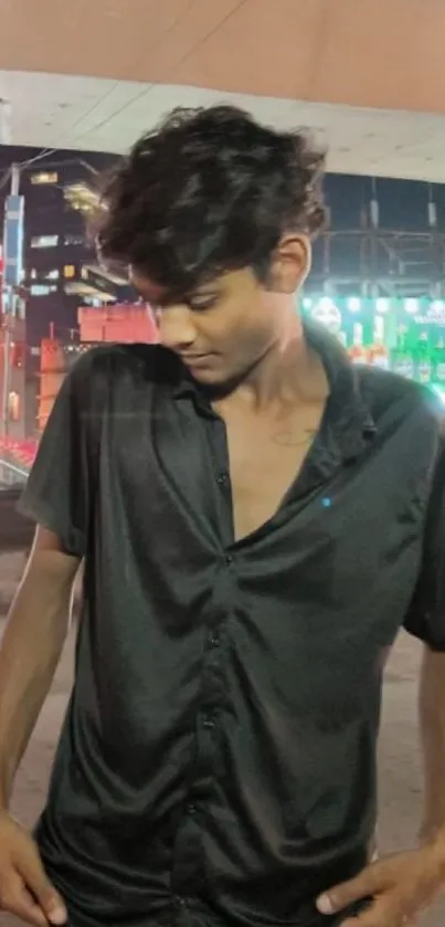 Stylish individual in black shirt enjoying the vibrant urban nightlife.