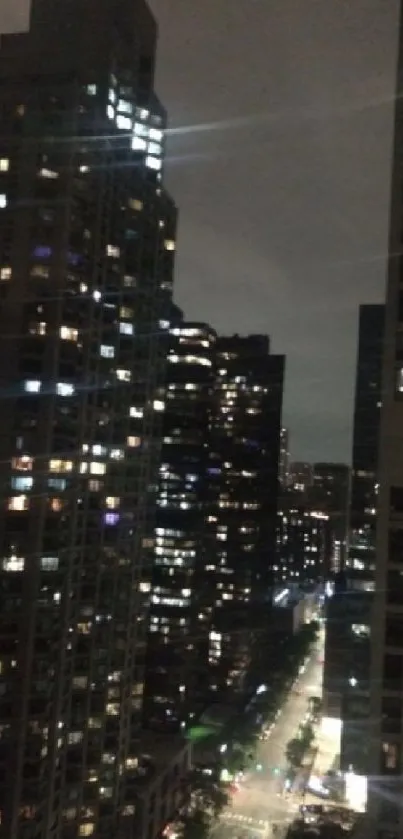 Vibrant city nightscape with illuminated buildings and lively street below.