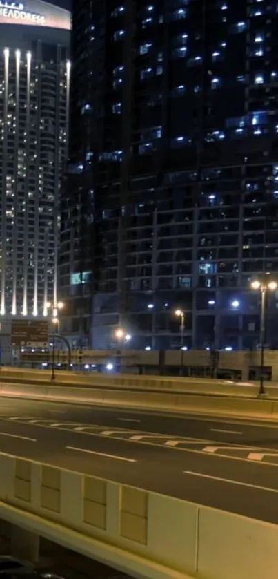 Illuminated skyscrapers at night with city lights.