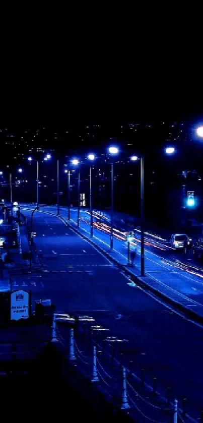 Blue urban nightscape with streetlights and buildings.