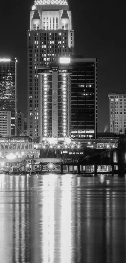 Black and white cityscape with skyline reflections at night.