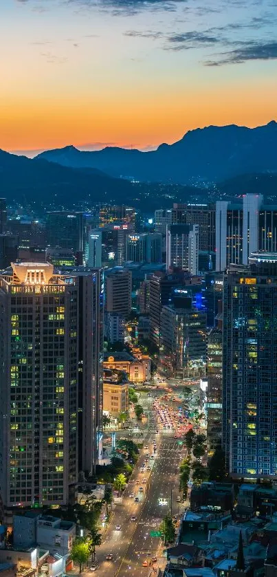 Vibrant cityscape with mountains at dusk, showcasing city lights and a colorful sky.