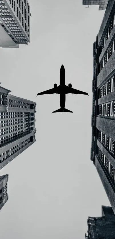 Silhouette of a plane flying over skyscrapers in grayscale urban setting.