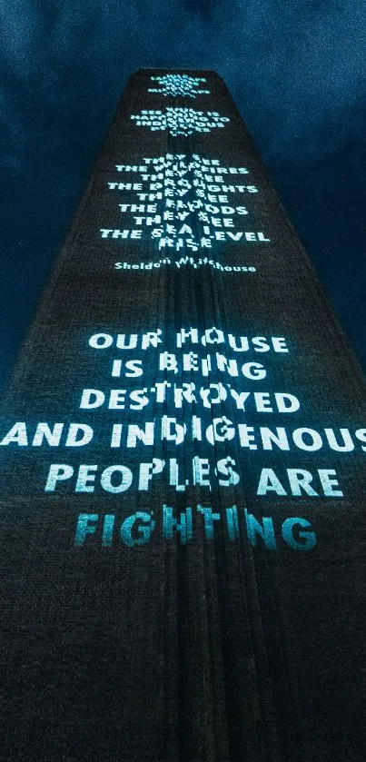 Projection art on building with illuminated messages against night sky.