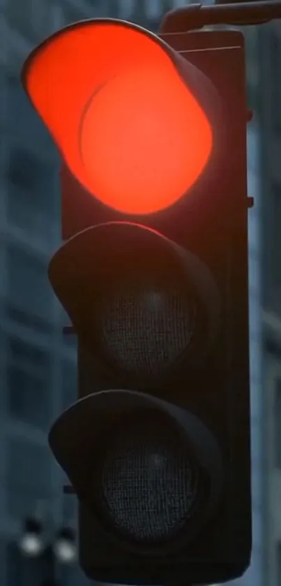 Red traffic light glowing in urban city scene.