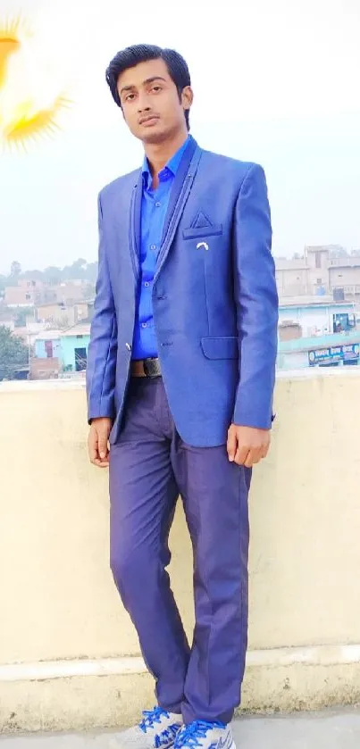 Man in blue suit on rooftop with city view and sun icon.