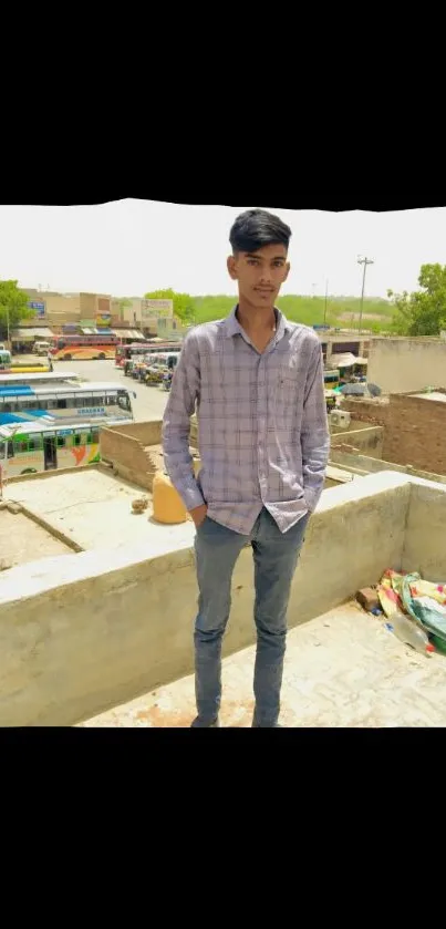 Young man on a rooftop with urban cityscape background.