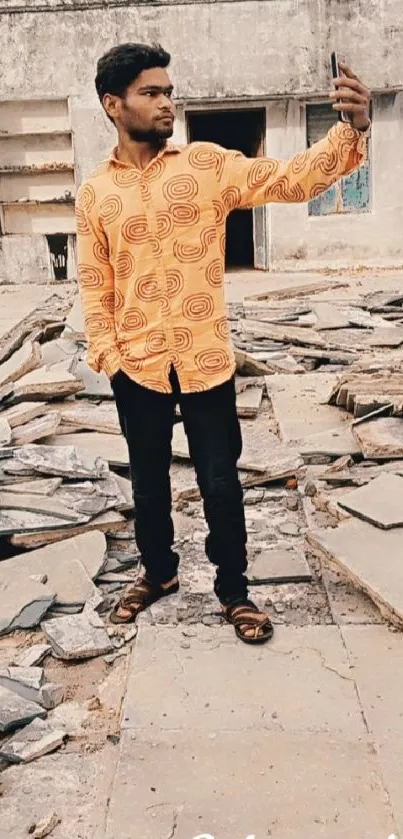 Man taking selfie in urban ruins with orange shirt.