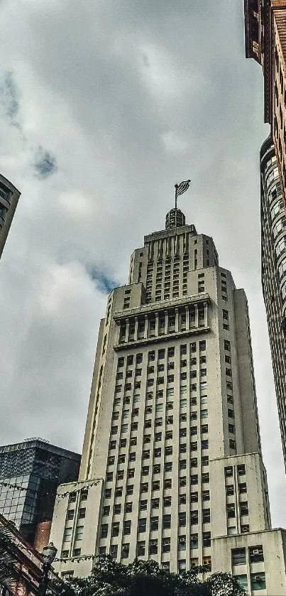 Tall skyscraper against a cloudy sky.