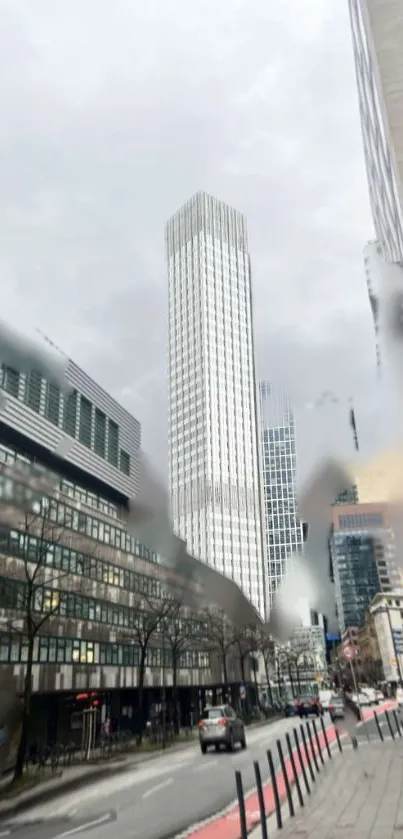 Skyscraper street view through raindrops on window.