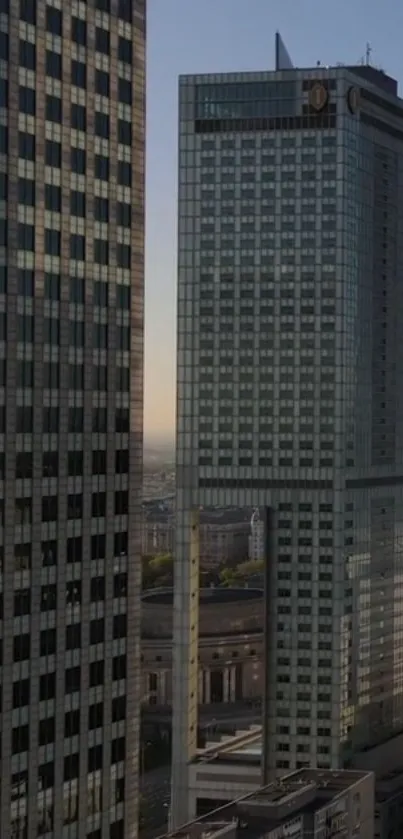 Tall skyscraper buildings in evening cityscape with clear sky.