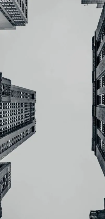 Monochrome view of skyscrapers from ground level with a cloudy sky.