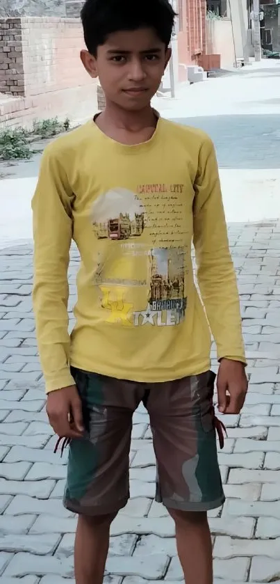 Young boy in yellow shirt on urban street wallpaper.