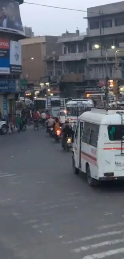 Busy city street with vehicles and pedestrians during evening rush hour.