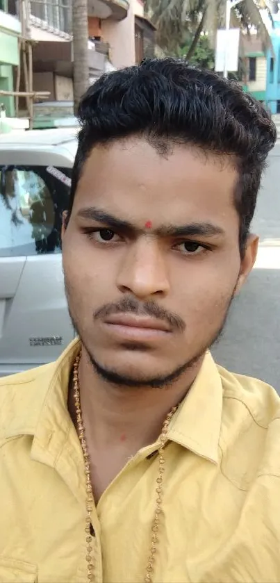 Urban street portrait with yellow shirt and city background.