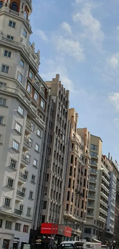 Bustling urban street with tall buildings against a light blue sky.