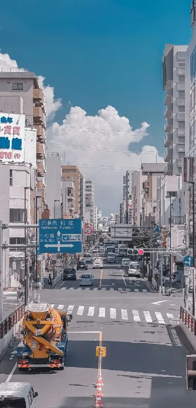 Lively urban street with bustling traffic and towering city buildings under a blue sky.