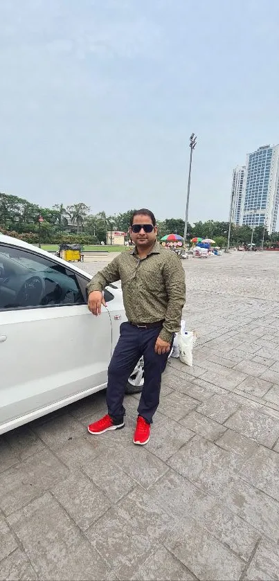 Person leaning on a white car with a cityscape in the background.