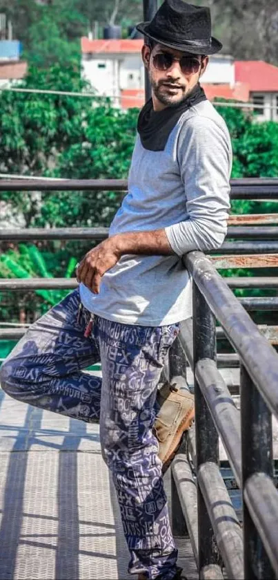 A stylish man in an urban setting wearing a black hat and sunglasses.