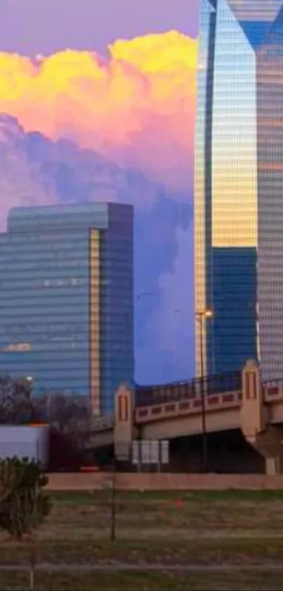 Illuminated city skyline during sunset with vibrant clouds and urban architecture.