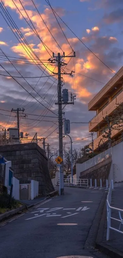 Urban street at sunset with glowing clouds and power lines.