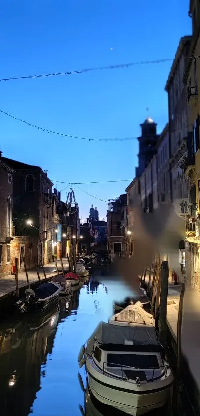 Venetian canal at dusk with boats and reflections in twilight.