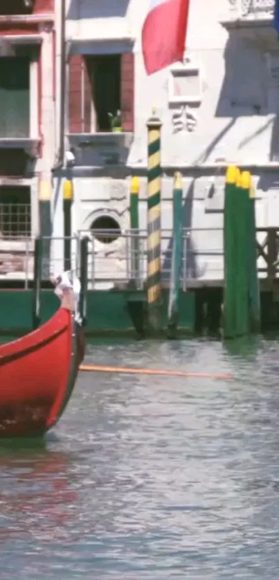 Venetian canal with a red boat and historic buildings.