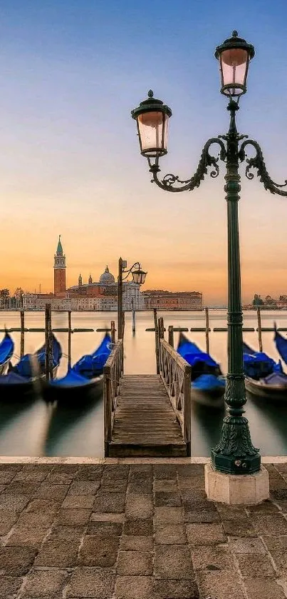 Venice gondolas at sunset with street lamp and orange sky.