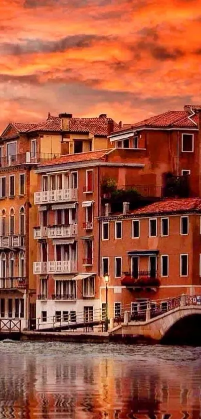 Venetian sunset with orange sky over historic buildings by the water.