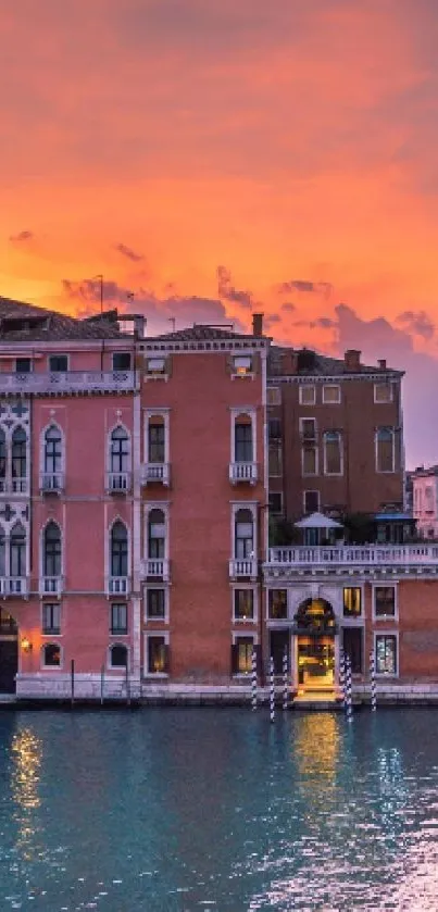 Beautiful Venice sunset view with orange sky and historic buildings.