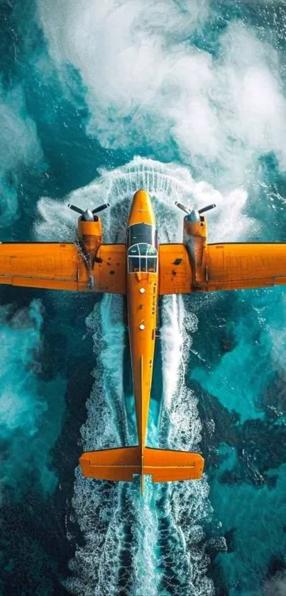 A vibrant orange airplane flying over a turquoise ocean view from above.