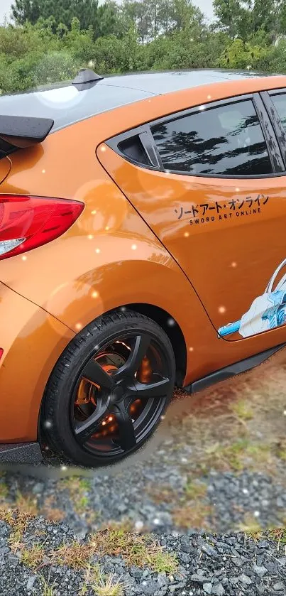 Orange anime-themed car with vibrant design on gravel road.