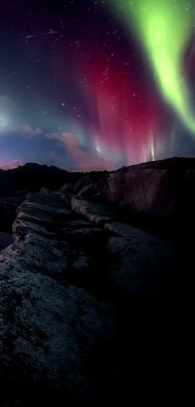 Aurora borealis illuminates rocky night landscape with stars.