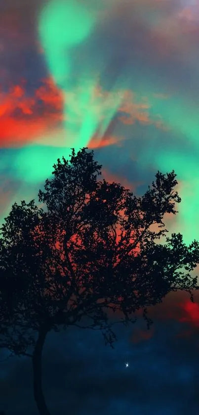 Silhouette of a tree under vibrant aurora night sky in teal and red hues.