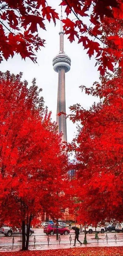 Autumn cityscape with vibrant red trees framing a prominent tower.