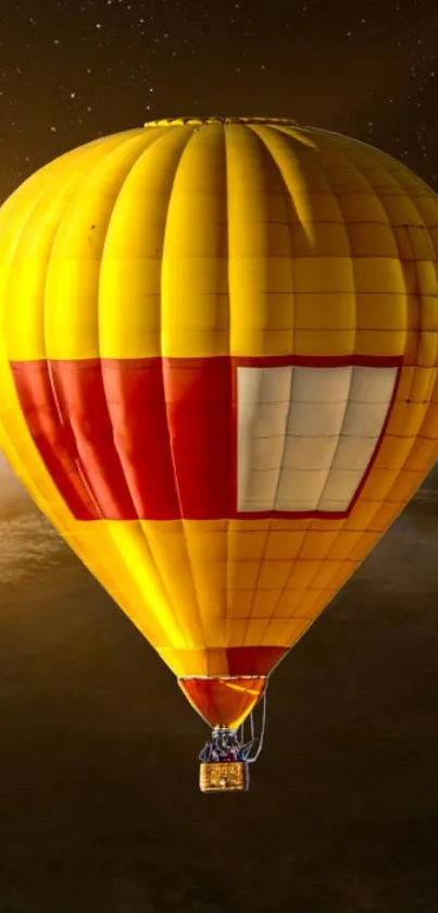 Yellow hot air balloon floating above Earth's night sky.