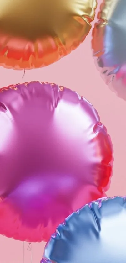 Colorful metallic balloons on pink background.