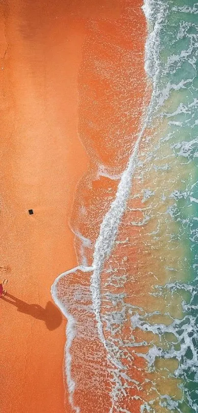 Aerial view of beach with orange sand and multicolored umbrella.