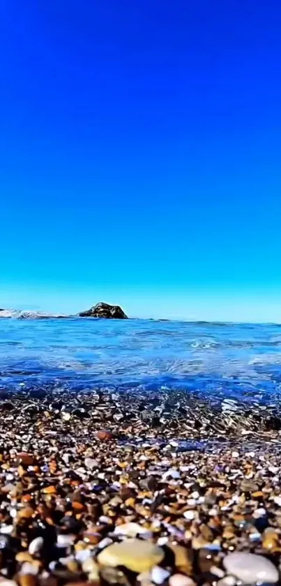 Vibrant beach with clear blue sky and pebbled shore.